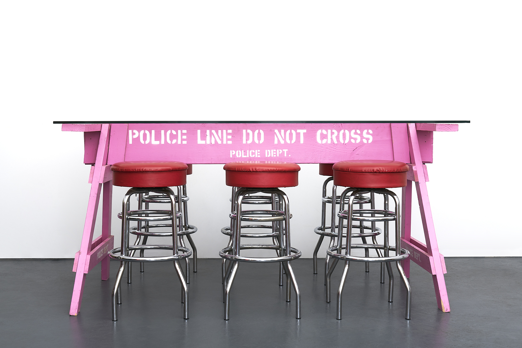 a pink sign table with stools. Carlo Sampietro