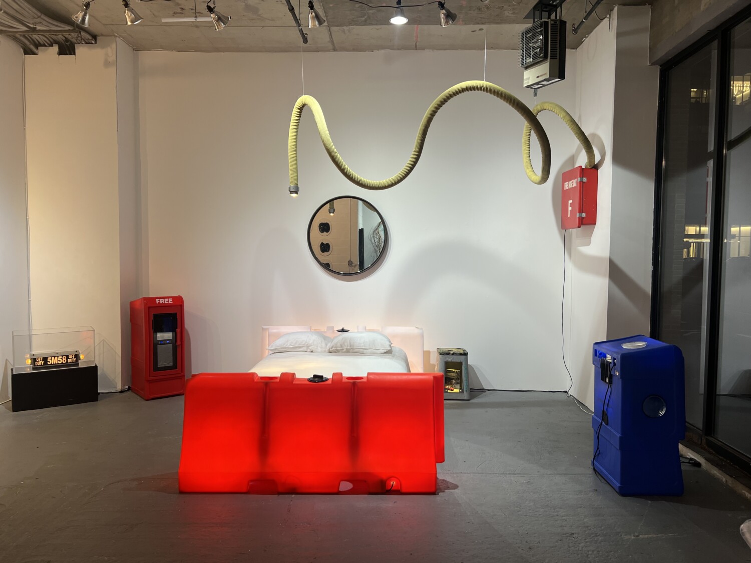 a red bed with a red tube from the ceiling. Carlo Sampietro