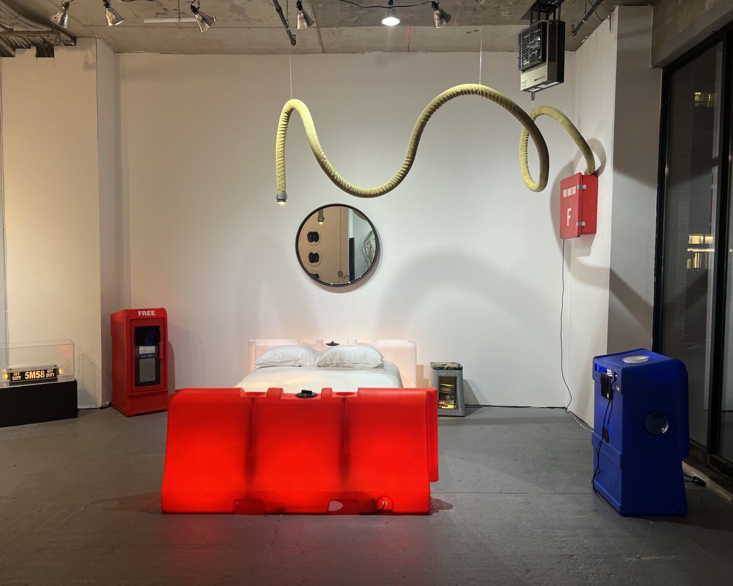 a red bed with a red tube from the ceiling. Carlo Sampietro